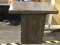 RUSTIC SIDE TABLE; WOODEN SIDE TABLE WITH A DARK FINISH. SOME WEAR. MEASURES 26 IN X 16 IN X 24.25