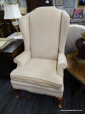 (R4) WINGBACK ARMCHAIR; ROLL ARM, CREAM UPHOLSTERED WINGBACK ARM CHAIR WITH CABRIOLE LEGS. MEASURES