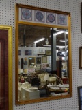 (RWALL) WALL HANGING MIRROR; BEVELED GLASS MIRROR IN A COPPER PAINTED WOODEN FRAME. HAS FLOWER