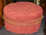 (R2) OTTOMAN; BUTTON TUFTED, ROUND OTTOMAN WITH A RED AND PINK FABRIC. HAS A SKIRT WITH TASSELS