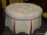 (R2) OTTOMAN; ROUND, BUTTON TUFTED OTTOMAN WITH A WHITE AND BEIGE TIGER FABRIC AND PINK BUTTONS. HAS