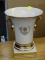 (R3) PORCELAIN VASE; TROPHY URN STYLE VASE WITH A CREAM AND GOLD TONE PAINTED FINISH. HAS LAUREL