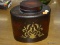 (R4) BOMBAY FLASK SHAPED JAR; HAS A FLORAL EMBOSSED AND PAINTED PATTERN ON THE FRONT. MEASURES 8.5