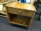 (R1) SIDE TABLE WITH DRAWER; WOODEN SIDE TABLE WITH A DRAWER WITH BRASS PULL ON CLOVER ESCUTCHEON.