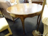 (R2) ROUND KITCHEN TABLE; WOODEN TABLE HAS A CARVED OUTLINE AROUND THE SCALLOPED SKIRT AND CABRIOLE