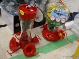 (R11) PAIR OF HUMMINGBIRD FEEDERS; TWO GLASS AND PLASTIC HUMMINGBIRD FEEDERS WITH RED BASES. ONE HAS