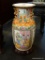 18 IN ORIENTAL VASE ON ROSEWOOD STAND WITH A DRAGONS ON THE SIDES AND HAND PAINTED WORSHIPING SCENE.