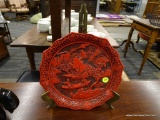 ORIENTAL RED LACQUER, CINNABAR CARVED CHARGER WITH BRASS PLATE STAND. HAS A 9.5 IN DIAMETER.