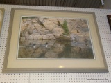 FRAMED DUCK PRINT; DEPICTS 2 DUCKS SWIMMING THROUGH A WATERWAY WITH A LARGE ROCK WALL IN THE