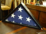 AMERICAN FLAG IN DISPLAY CASE. SITS IN A BLACK FLAG CASE. MEASURES 26.25 IN X 13.25 IN.