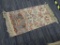 DOOR MAT; WOOL PILE, MACHINE WOVEN DOOR MAT WITH A BEIGE, PINK, AND BLUE FLORAL PATTERN. HAS FRINGES