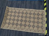 UPSWEPT WELCOME MAT; HAS A TRELLIS PATTERN AND A NATURAL/RED COLOR. HAS A GEOMETRIC PATTERN.