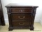 (UPBR) MAHOGANY THREE DRAWER NIGHT STAND; HAS BLACK INLAY DETAILING ALONG THE TOP, FLORAL CARVED