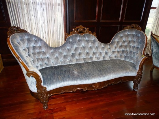 (LIBRARY) VICTORIAN CAMELBACK SOFA; PALE BLUE UPHOLSTERED WITH BUTTON TUFTED BACK. CARVED ORNATE