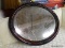 (R4) WHITE SEID HANGING MIRROR; OVAL MIRROR IN A RED AND BLACK PAINTED WOODEN FRAME WITH FLORAL