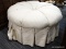 (R4) ROUND OTTOMAN; SINGLE BUTTON TUFTED, WHITE AND BEIGE STRIPED, ROUND OTTOMAN WITH CHEETAH PRINT