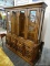 (WALL) RUSTIC CHINA CABINET; TWO PIECE WOODEN CHINA CABINET. TOP PIECE HAS FLARED CORNICE TOP,