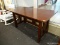 (WINDOW) WOODEN DESK; CHERRY FINISHED DESK WITH MISSING SLIDING TABLE. MEASURES 67 IN X 29.25 IN X