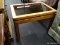 (R1) END TABLE; WOODEN GLASS TOP END TABLE WITH FINGER LOCK CONSTRUCTION. MEASURES 17.75 IN X 25.75