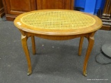 (R1) CANE OVAL PIANO BENCH; HAS ROUNDED SKIRT, CABRIOLE KNEES WITH METAL CAPPED FEET. CANE IS