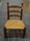 (R2) CHERRY CHILD'S CHAIR; SLAT BACK CHILD'S CHAIR WITH A RUSH BOTTOM SEAT AND A BOX STRETCHER.