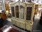 (R2) BREAKFRONT CHINA CABINET; 2 PC. LIGHT BROWN CHINA CABINET. TOP PIECE HAS SCROLLING ACCENTS, 2