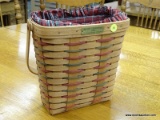 (R2) LONGABERGER MERRY CHRISTMAS 1991 BASKET WITH A PLAID CLOTH AND PLASTIC BASKET INTERIOR.