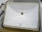 (R1) BATHROOM SINK; WHITE RECTANGULAR UNDERMOUNT BATHROOM SINK. HAS GLUE AROUND THE EDGES. MEASURES