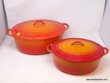 (LEFT WALL) COOKWARE; 2 CAST IRON AND ENAMEL OVAL ROASTERS- 16 IN X 8 IN AND 13 IN X 7 IN.