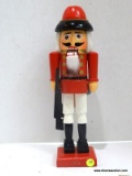 (R4) SOLDIER NUTCRACKER HOLDING A GUN IN HIS RIGHT HAND - RED WITH WHITE PANTS. MEASURES 15