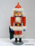 (R4) ERZGEBIRGE SANTA NUTCRACKER HOLDING A GREEN SACK IN HIS RIGHT HAND. MEASURES 14.25