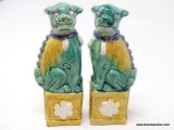 (RFRT) PAIR OF CERAMIC FOO DOGS; 2 PIECE SET OF GREEN AND BURNT YELLOW FOO DOGS SITTING ON A