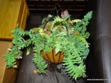 (R4) WROUGHT IRON HANGING PLANTER; GLOSSY BLACK SCROLLING PLANTER FILLED WITH FAUX FERNS AND LEAVES.