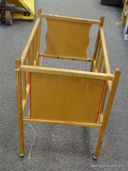DOLL CRIB; VINTAGE, ROLLING DOLL CRIB WITH WOODEN CASTERS. MISSING BOTTOM.