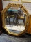 (WALL) OCTAGONAL MIRROR; GOLD TONED, SCROLL AND FLORAL DETAILED, WLAL HANGING MIRROR. MEASURES 31