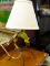(R4) WROUGHT IRON TABLE LAMP WITH HANGING, PAINTED METAL LEAF ACCENTS. COMES WITH A CREAM LINEN