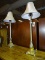 (R1) PAIR OF TABLE LAMPS; 2 PIECE SET OF CHAMPAGNE COLORED TABLE LAMPS, 1 HAS A LEAF DETAILED URN