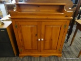 (R2) STAINED PINE CABINET; 2-DOOR PINE CABINET WITH A SINGLE SHELF AND A RAISED BOWL TOP WITH A