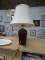 (SHELVES) TABLE LAMP; BURGUNDY, GLASS TABLE LAMP WITH A PLATINUM BASE AND TOP. COMES WITH A CREAM
