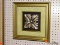 (LWALL) FRAMED ART; SILVER PAINTED FLORAL LEAF SHAPE SITTING IN A GREEN MAT AND A BRONZE TONED