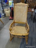 (R3) VINTAGE ROCKING CHAIR; WOODEN ROCKING CHAIR WITH GOOSENECK LIKE ARMS AND A CANE BACK AND SEAT.