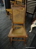 (R4) CANE ROCKING CHAIR; WOODEN ROCKING CHAIR WITH A BANNISTER TOP AND A CANE BACK AND SEAT.