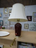 (SHELVES) TABLE LAMP; BURGUNDY, GLASS TABLE LAMP WITH A PLATINUM BASE AND TOP. COMES WITH A CREAM