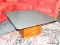 MID-CENTURY MODERN WALNUT SQUARE BASE COFFE TABLE WITH GRANITE SQUARE TOP AND ROUNDED EDGES.