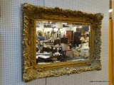 DESIGNER GOLD GILT BEVELED MIRROR IN HIGHLY ORNATE FRAME. MEASURS APPROX. 49.5