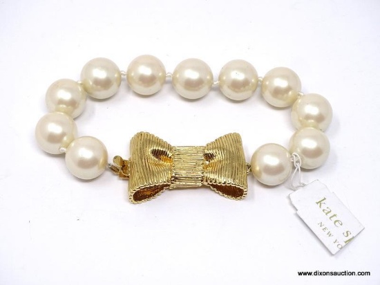 DESIGNER SIGNED, KATE SPADE "ALL WRAPPED UP IN PEARLS" BOW BRACELET. FEATURES OVERSIZED SIMULATED