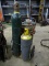 WELDING TANK CART WITH AN ACETYLENE TANK, A LARGER OXYGEN TANK, HOSES, AND GAUGES AND ATTACHMENT.