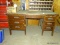 OLD WOODEN DESK WITH 4 DRAWERS AND 1 DOOR. MEASURES 5' X 2' 10