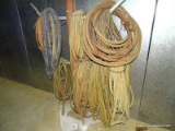LARGE LOT OF HOSES AND PLASTIC TUBING HANGING ON STAND.