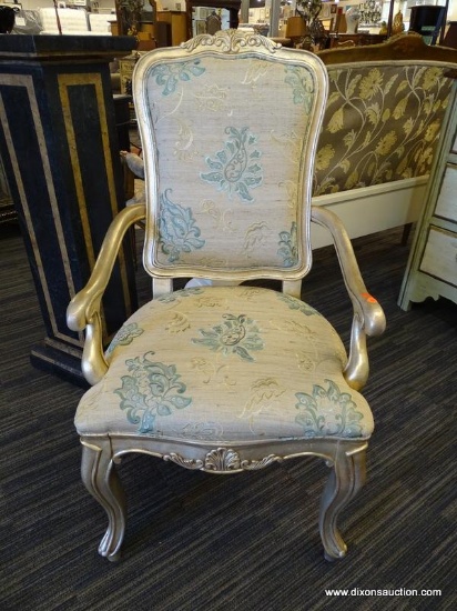 FRENCH PROVINCIAL ARM CHAIR; HAS CREAM AND TEAL PAISLEY PATTERN UPHOLSTERY AND A SHELL CARVED CREST.